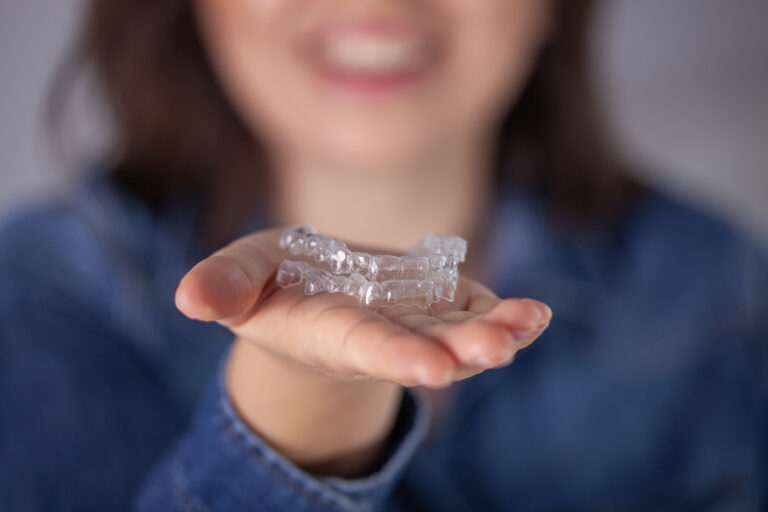 Woman Holding Clear Aligners For Teeth Straightening Modern Invisible Orthodontic Treatment.
